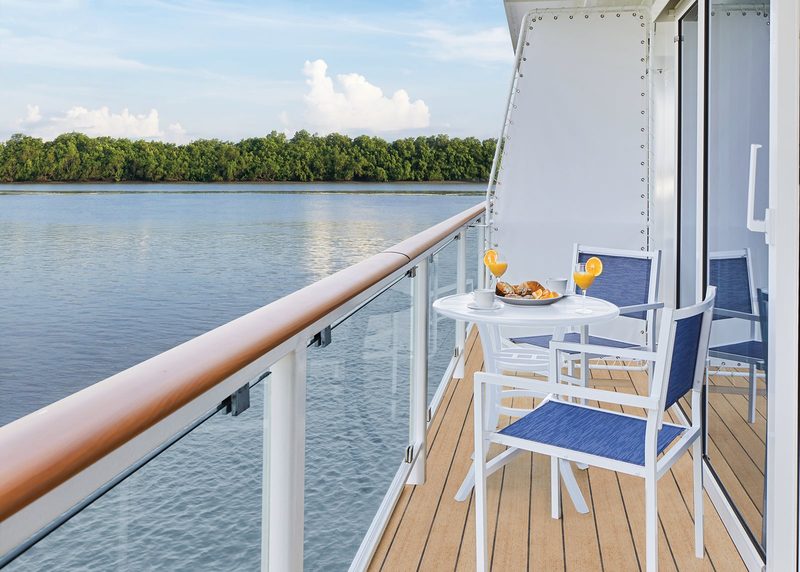 A private balcony aboard the American Symphony, table and chairs set out over the water