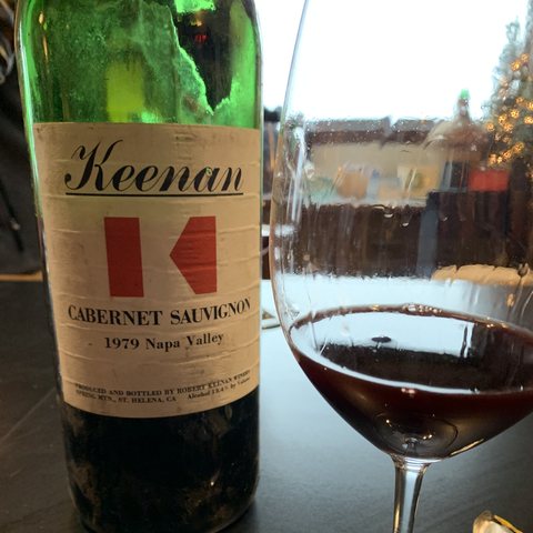 A bottle of 1979 Keenan Cabernet Sauvignon, Napa Valley, with the red K label, beside a glass of the wine