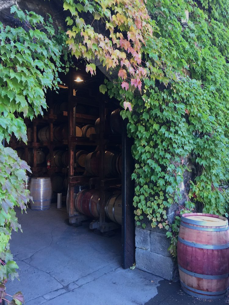 The ivy-covered stone entrance to the Keenan cellar, racked barrels visible inside