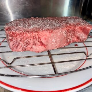 The strip dry-brined with kosher salt, resting uncovered on a wire rack
