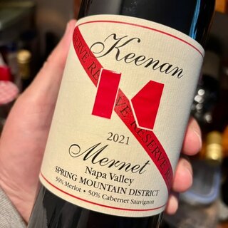 A bottle of Keenan 2021 Mernet Reserve held up to the light