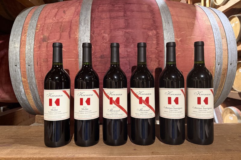 The Keenan Reserve Club shipment against a barrel — six reds, two of them carrying the red Reserve banner across the corner of the label