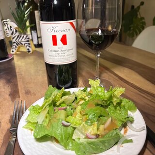 A garden salad with blueberry vinaigrette beside the Keenan Reserve Cabernet Sauvignon