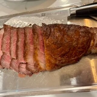 The seared rib eye with a deep mahogany crust, cut to show the interior