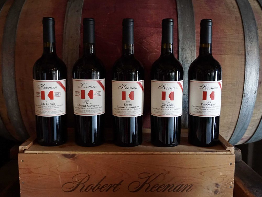 A lineup of secret Keenan wine bottles on a Robert Keenan Winery wooden crate