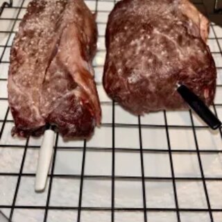 Two Wagyu chuck eyes on a wire rack after the low-and-slow oven stage
