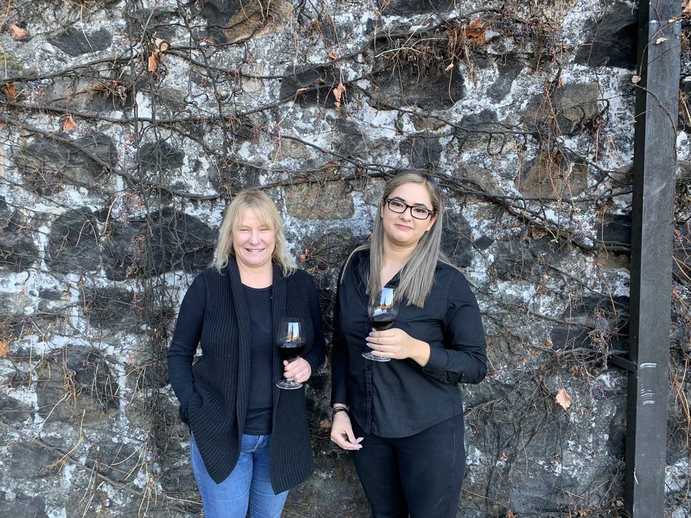 Laura March and Elizabeth Zafra against the Conradi stone wall
